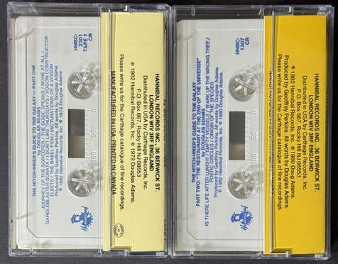 Douglas Adams – The Hitch-Hiker’s Guide To The Galaxy: Part One / Part Two – The Restaurant At The End Of The Universe (2-Cassette Set, 1982, Hannibal Records)